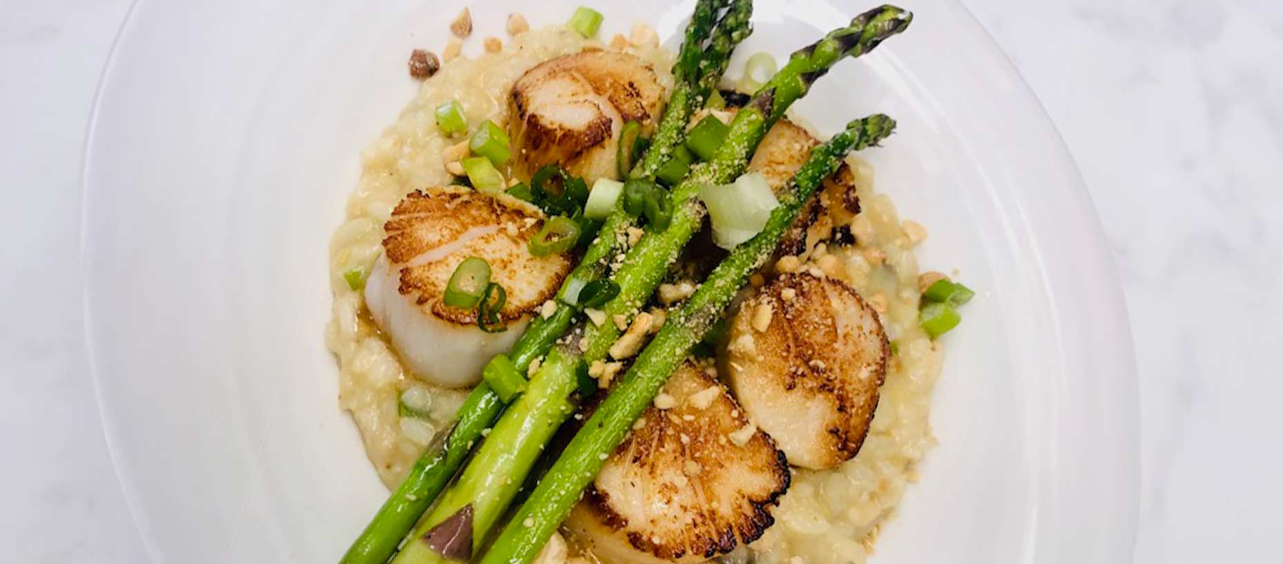 braised scallops on bed of risotto with grilled asparagus on top<br />

